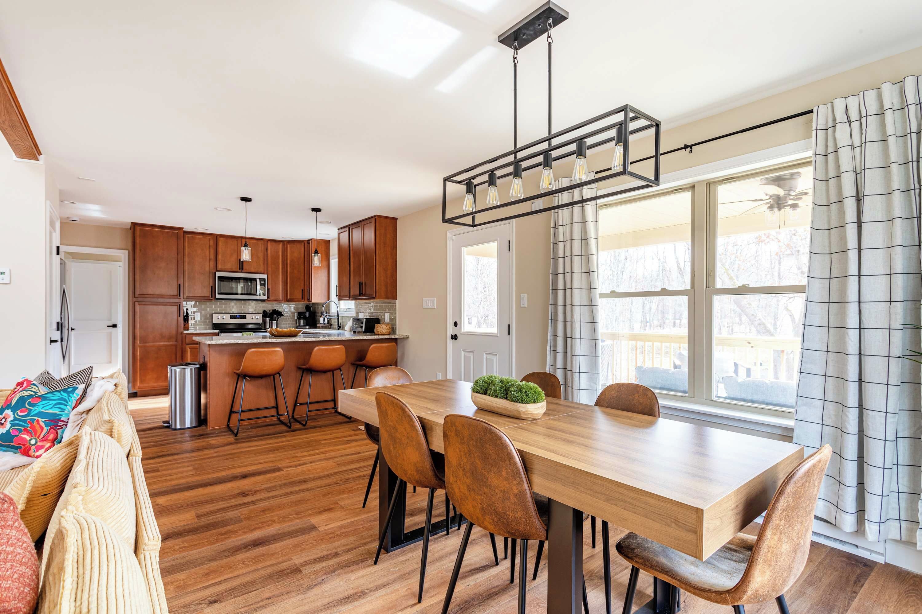 A modern kitchen with wooden cabinets, a stainless steel refrigerator, and a built-in microwave.