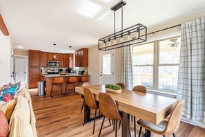 A modern kitchen with wooden cabinets, a stainless steel refrigerator, and a built-in microwave.