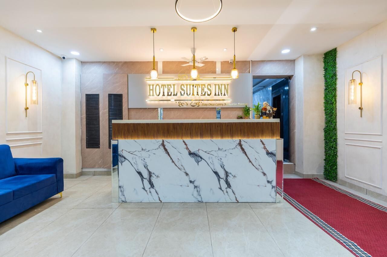 A hotel reception desk with a marble top, a blue sofa, and a red carpet.
