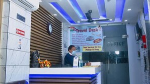 A travel desk with a sign advertising services like taxi pickups and drop-offs. - Hotel Delhi Darshan -By RSL Hospitality (New Delhi)