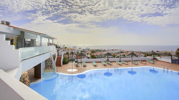 A rooftop pool with lounge chairs and a view of the city and sea. - CASA DEL SOL, Beautiful Terrace, Fast Wi-Fi, Pool (COSTA ADEJE)