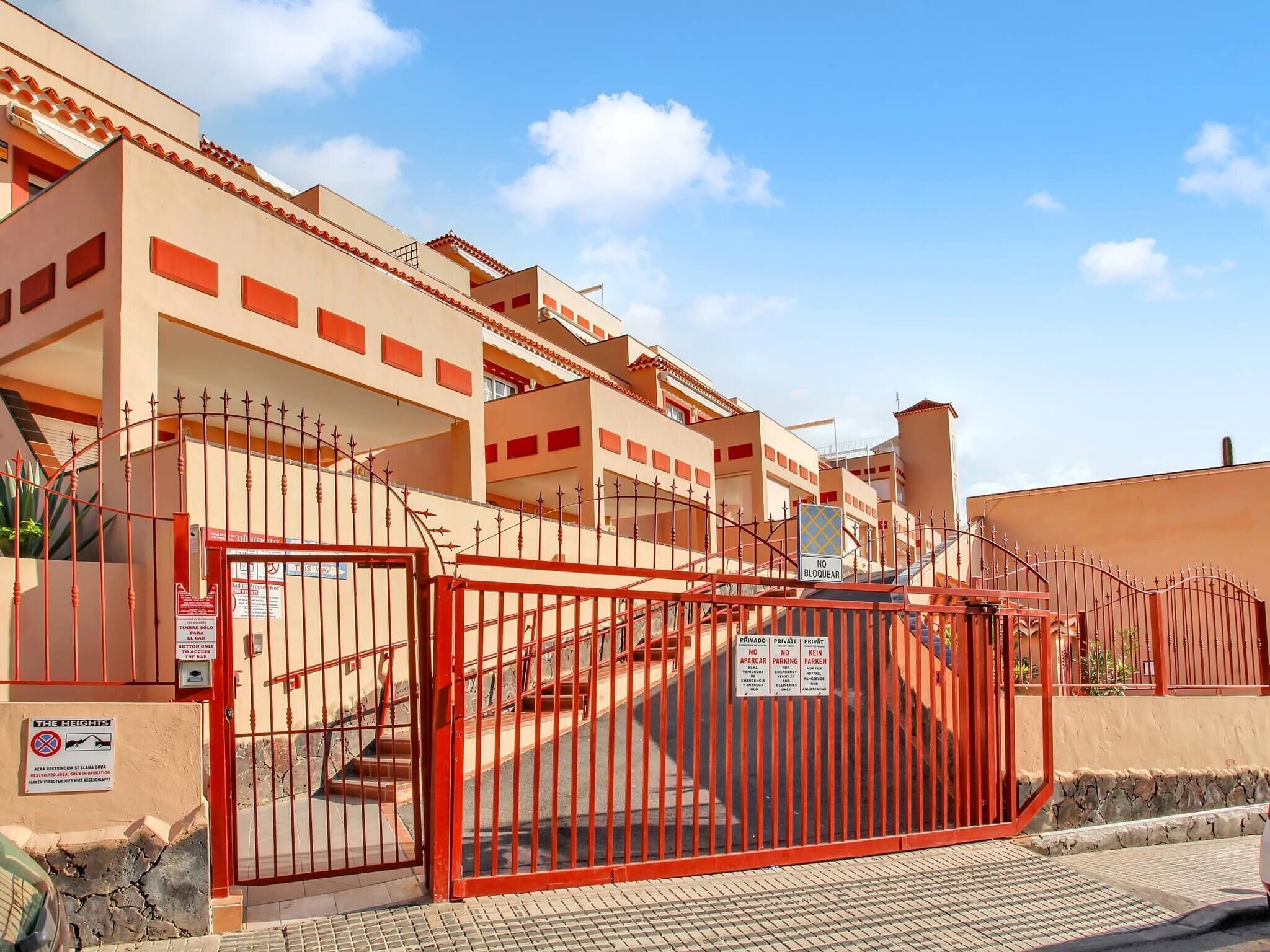 Ein geschlossener Wohnkomplex mit mehreren Gebäuden, einer Treppe und einem Verbotsschild für Fahrzeuge.