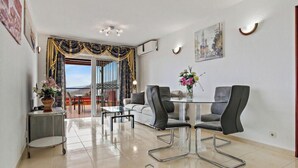 Uma área de refeições moderna com uma mesa de vidro, cadeiras pretas e vista para o exterior.