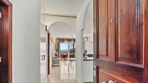 Corredor que leva a uma sala de jantar com vista para o exterior.