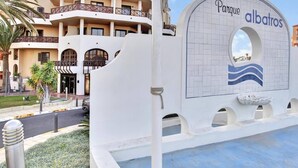 A hotel with a white facade, multiple balconies, and a sign reading "Parque albatros".
