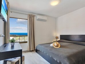 Enjoy a serene ocean and city view from the large window in this stylish room.