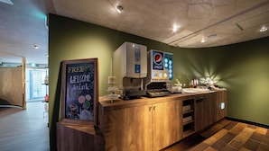 A reception area with a wooden counter, a Pepsi vending machine, and a sign offering free drinks. - MANORHOUSE - Adult Only (Warabi)