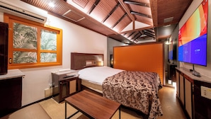 A hotel room with a bed, a desk, a TV, and a window with a tropical leaf pattern. - MANORHOUSE - Adult Only (Warabi)