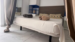 Un dormitorio moderno con cama, un mueble de almacenamiento azul y un cabecero con líneas horizontales.