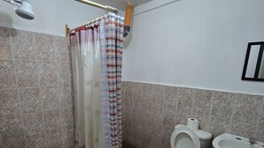 A bathroom with a shower curtain, a toilet, and a sink. - Apartamentos el viajero (Panajachel)