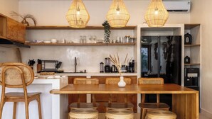 Eine moderne Küche mit Holzmöbeln, Korbstühlen und Pendelleuchten.