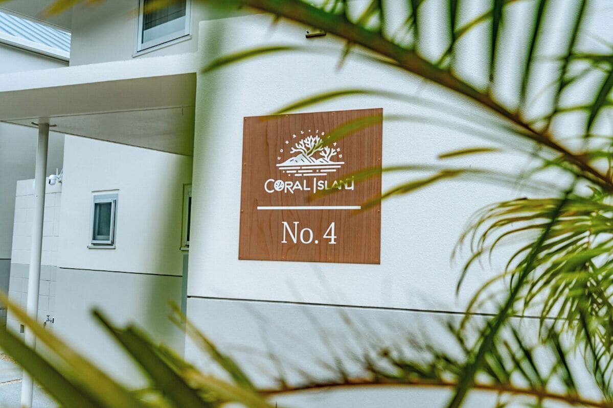 A building with a sign reading "CORAL ISLAND No.4" and a window.