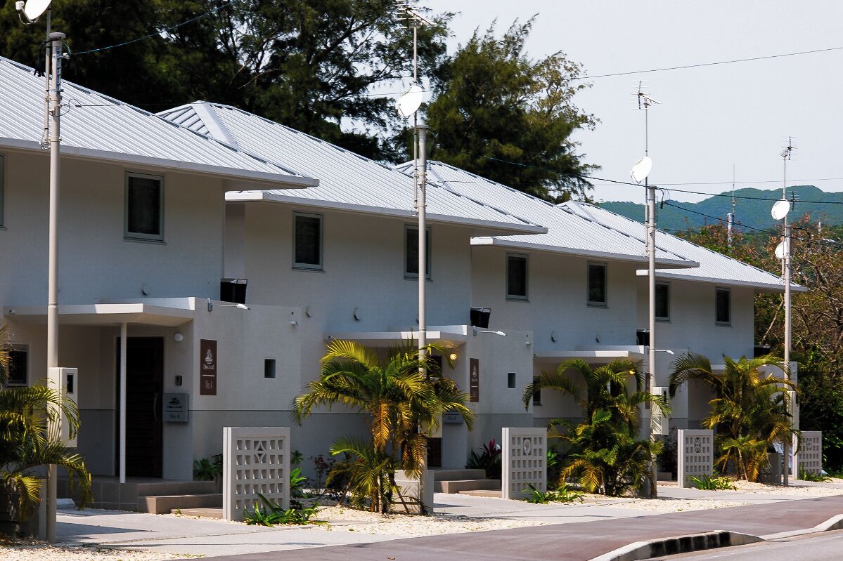 A row of modern, single-story buildings with a flat roof, likely a hotel or residential complex.