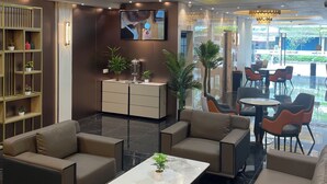 Een moderne zithoek met banken, een salontafel en een televisiescherm.