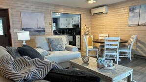 Uma sala de estar aconchegante com sofá, mesa de centro e área de jantar.
