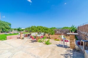 Relax in style with a central table and four comfortable chairs amidst lush greenery and a scenic view.