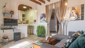 A cozy living room with a sofa, a wooden coffee table, a television, and a potted plant. - Can Potdir - Villa With Private Pool In Ariany (Ariany, Illes Balears)