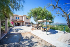 Una casa con patio, mobiliario exterior y vistas al paisaje.
