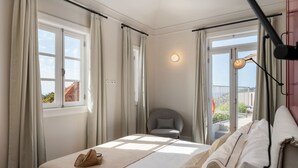 A bedroom with a bed, a chair, a balcony, and a view of the outside. - Beautiful villa with rooftop pool | CarmHim (Calheta)