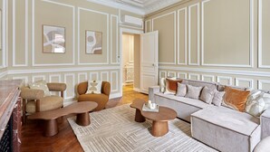 A spacious living room with a sofa set, coffee table, and a fireplace. - Magnificent Apartment Etoile Hoche Saint Honore (Paris)