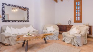 Un salon chaleureux avec deux canapés, une table basse en bois, un grand miroir et un meuble en bois.