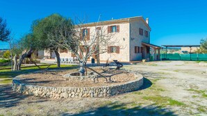 A stone building with a courtyard, outdoor seating, and a view of the surrounding landscape.