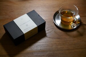 Una caja negra con una etiqueta sobre una mesa de madera.
