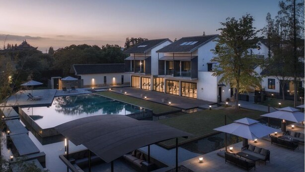 A modern villa with a swimming pool, outdoor seating, and a view of the surrounding landscape. - Tan Alley Wuzhen Eco and Cultural Community (Jiaxing)