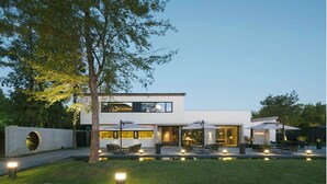 A modern two-story house with a patio area, outdoor seating, and a swimming pool. - Tan Alley Wuzhen Eco and Cultural Community (Jiaxing)