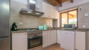 A compact kitchen with a gas stove, oven, microwave, and dishwasher.