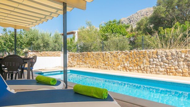 A poolside area with lounge chairs and a stone wall. - Can Clavell - Villa With Private Pool. Free Wifi (Colonia De Sant Pere (artà), Illes Balears)