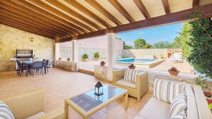 A covered outdoor patio with a dining area, lounge seating, and a view of a swimming pool. - Villa Gloria - Villa With Private Pool In Cala Pi (Cala Pi , Illes Balears)