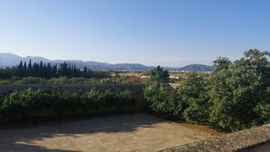 A courtyard with a view of distant mountains and trees.