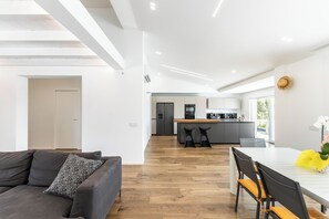 Un intérieur moderne comprenant un canapé, une table à manger et un coin cuisine.