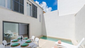 A sunlit outdoor dining area with a pool, white walls, and a clear blue sky. - Na Valenta - Villa With Private Pool In Artà (Artà, Illes Balears)