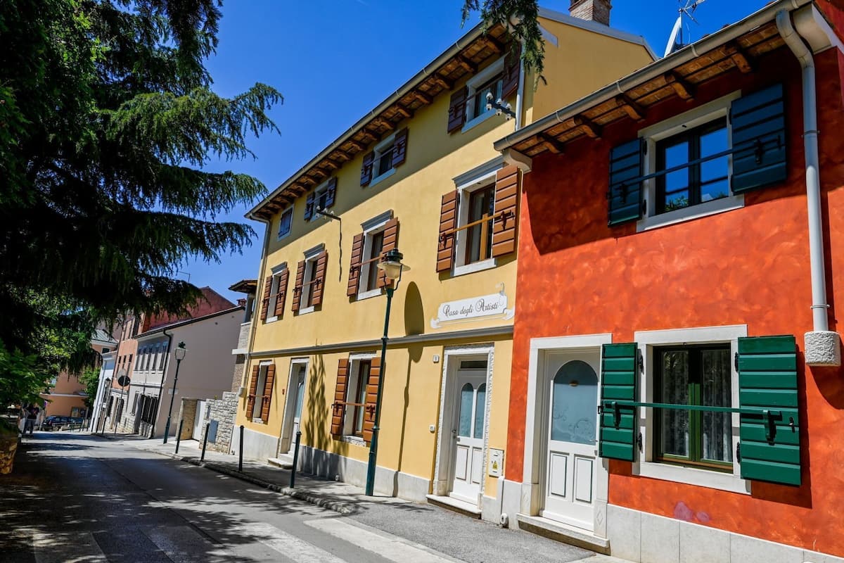 Un edificio a due piani con facciata gialla e una sezione rossa sulla destra.