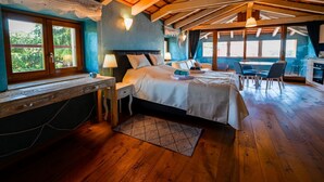 A bedroom with a wooden ceiling, a bed, bedside tables, a desk, and a view of the outdoors. - Georgeous and Warm Living Downtown Rovinj (Rovinj)