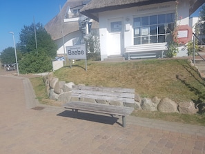 A building with a sign reading 'Hafenmeister Baabe,' a bench, and a grassy hill. - Apartment 'Ostseesonne' with Balcony and Wi-Fi (Baabe)