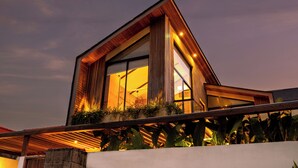 A modern building with large windows and a wooden facade. - Nanna Villa Unit 1 by Betterplace (Canggu)