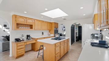 Una cocina moderna con armarios de madera, una isla central y un tragaluz.