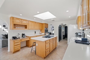 A modern kitchen with wooden cabinets, a central island, and a skylight. - Foothills Oasis Heated Pool&HotTub Stunning Views (Tucson)
