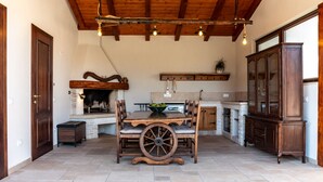 A rustic kitchen with a wooden table, a fireplace, and a large wooden cabinet. - Villa Lere by Villas Guide (Ližnjan)