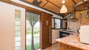 A kitchen with a wooden door marked "14D," a tiled backsplash, and a hanging light fixture. - Casa Amelie - Villa With Private Pool. Free Wifi (, Cádiz)