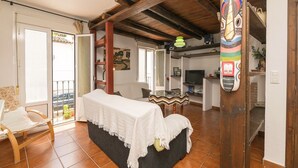 Un vaste espace de vie comprenant un canapé, une table à manger et un balcon.