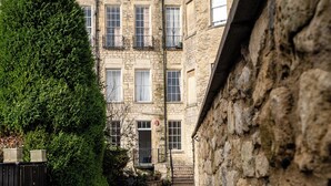 A stone building with multiple windows and a gated entrance. - Garden Flat Apartment in Grosvenor Place (Bath)