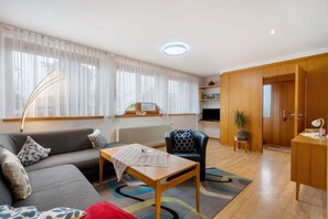 Una sala de estar moderna con un sofá, una mesa de centro, una silla y un mueble de madera.