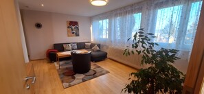 Una sala de estar moderna con un sofá, una mesa de centro y una planta.