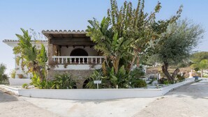 A building with a balcony, surrounded by lush greenery and a clear sky. - Almarchada 38 - Villa With Private Pool In Mijas (, Málaga)