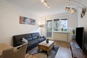 Una sala de estar moderna con un sofá, una mesa de centro y una televisión.
