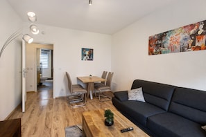Una sala de estar moderna con sofá, mesa de centro y un cuadro en la pared.